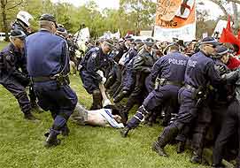 Police carry away a protestor as others control a crowd of anti-war demonstrators outside the USA embassy in Canberra.