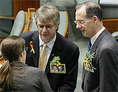 Green Party Senator Bob Brown and MP Michael Organ talk with Senator Kerry Nettle whilst wearing pictures of the two Australian citizens being held at Guantanamo Bay.