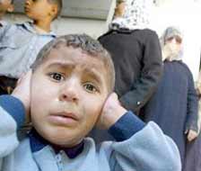 A disturbed Palestinian child covers his ears after an Israeli warplane fired a missile on a car in Zeitoun.