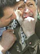 Yasser Arafat, listening to his bodyguard, surveys the damage to his Ramallah headquarters, after Israeli forces partially demolished it.
