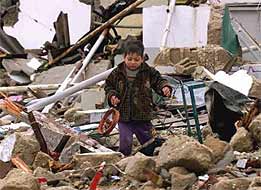 A Palestinian child cries as he recovers a homemade toy from the rubble of his destroyed house in Rafah, Gaza Strip.