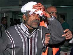 Palestinian medical workers at Shifa hospital in Gaza City escort a Palestinian policeman wounded when Israeli warplanes and helicopter gunships attacked the Palestinian security headquarters in Gaza.